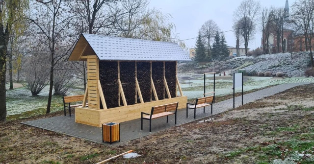 Zdjęcie tężni solankowej wraz z małą architekturą (ławki, śmietniczki, tablica informacyjna).